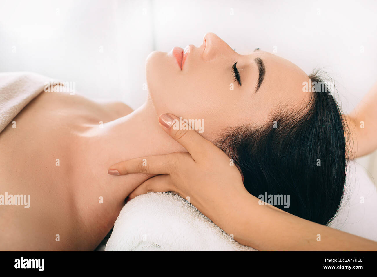 Brunette Woman relaxing during spa treatment . She receive relaxation massage while spa weekend Stock Photo