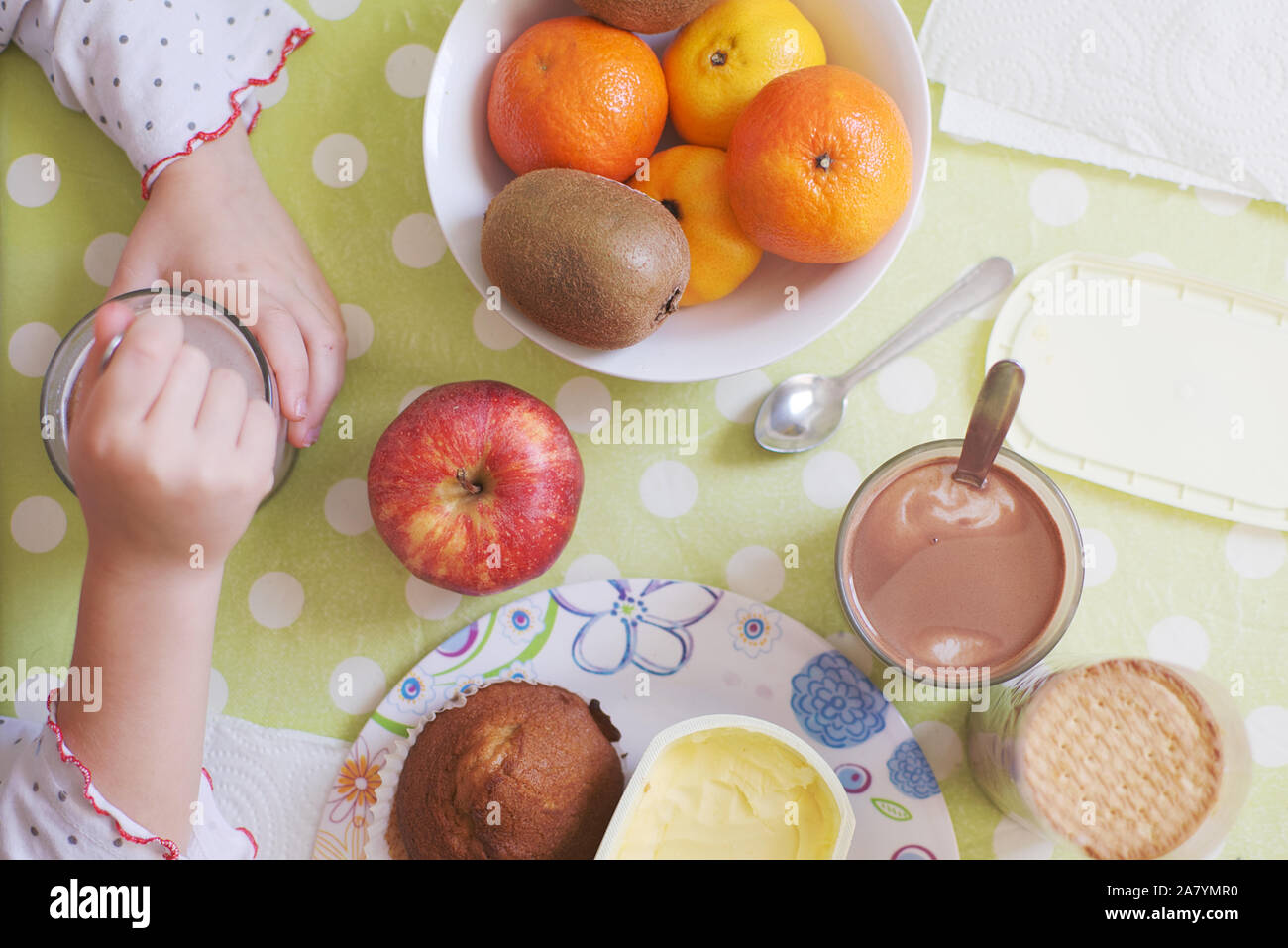 Little girl taking beakfast at home, top view. Children nourishment concept an empty copy space. Stock Photo