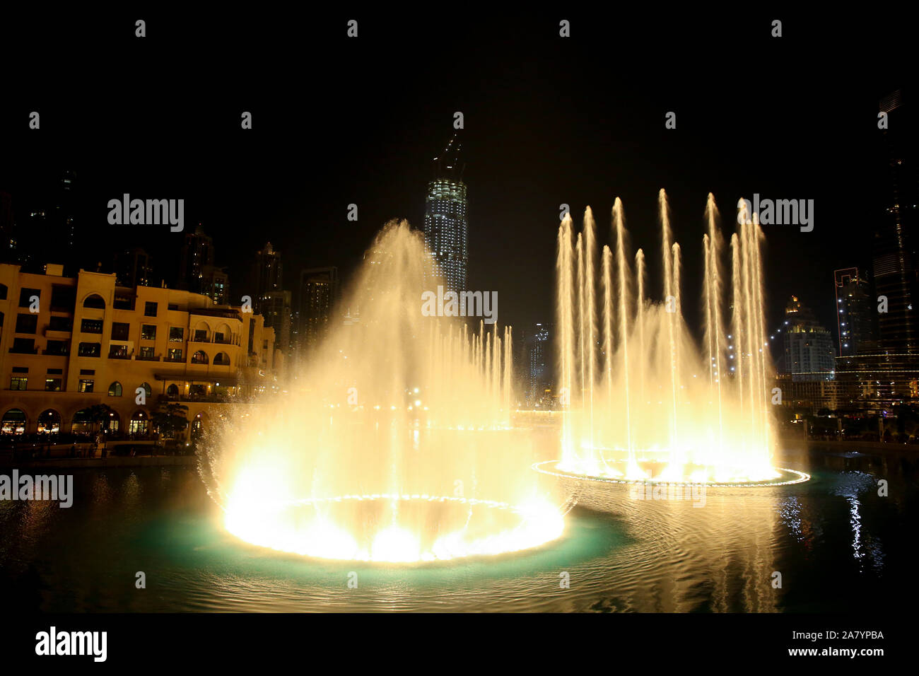 Water & Light show in the downtown city at night with all the skyscrappers illluminated and reflecting in the lake, Dubai, United Arab Emirates. Stock Photo