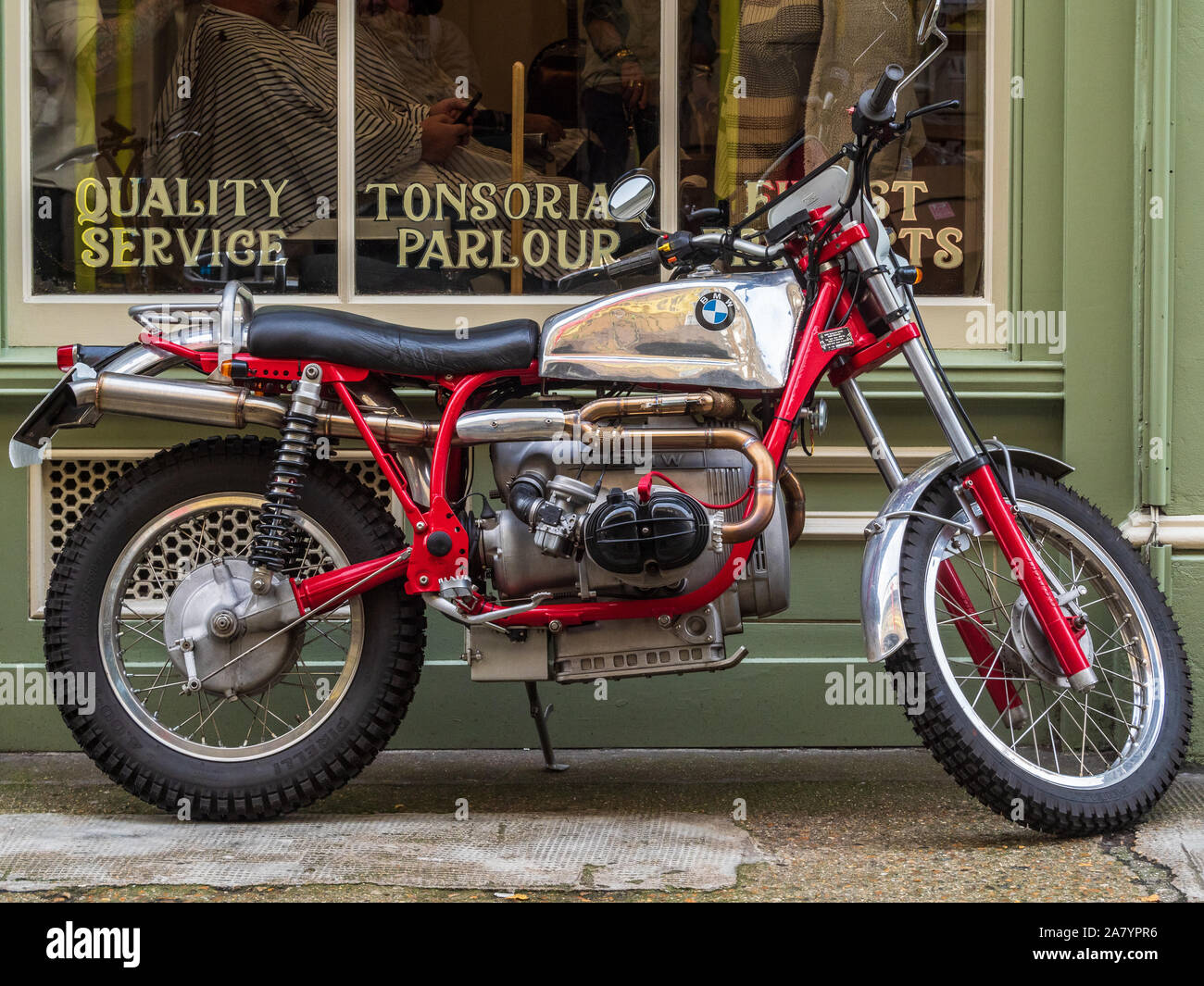 Trendy Shoreditch - custom BMW scrambler motorcycle in front of Thy Barber store in Cheshire Street off London's Brick Lane in fashionable Shoreditch Stock Photo