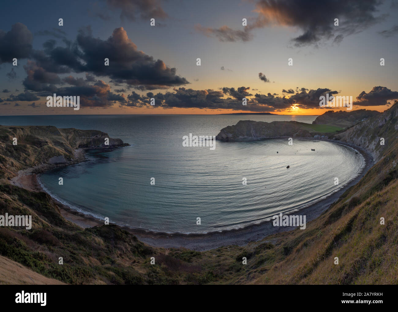 Lulworth Cove Dorset England Panoramic view of Lulworth Cove at Sunset. Lulworth Cove is one of the best known parts of Dorset's Jurassic Coast. Stock Photo