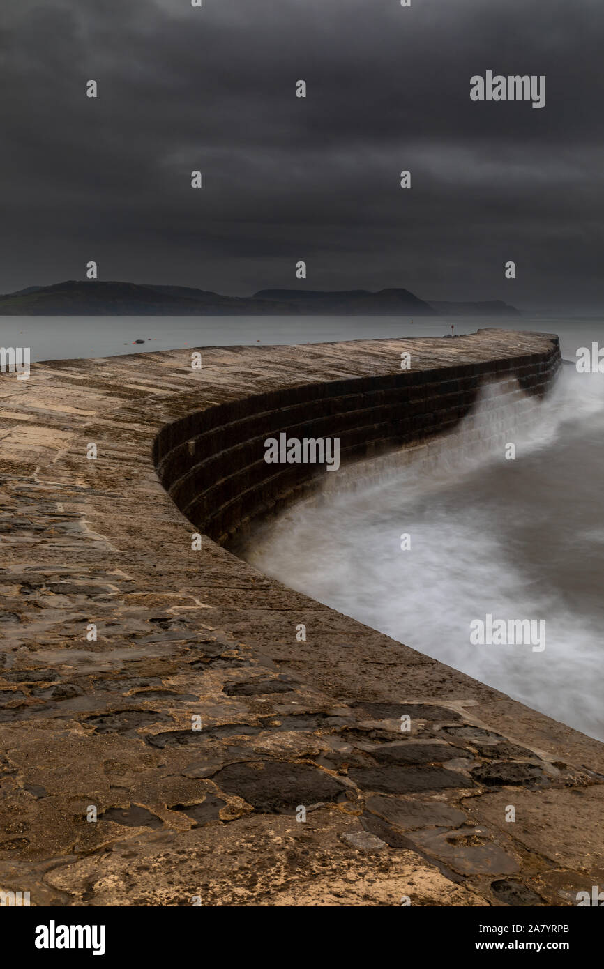 Lyme Regis Dorset England Dawn at The Cobb, the historic harbour wall of Lyme Regis, during stormy, rainy weather Stock Photo