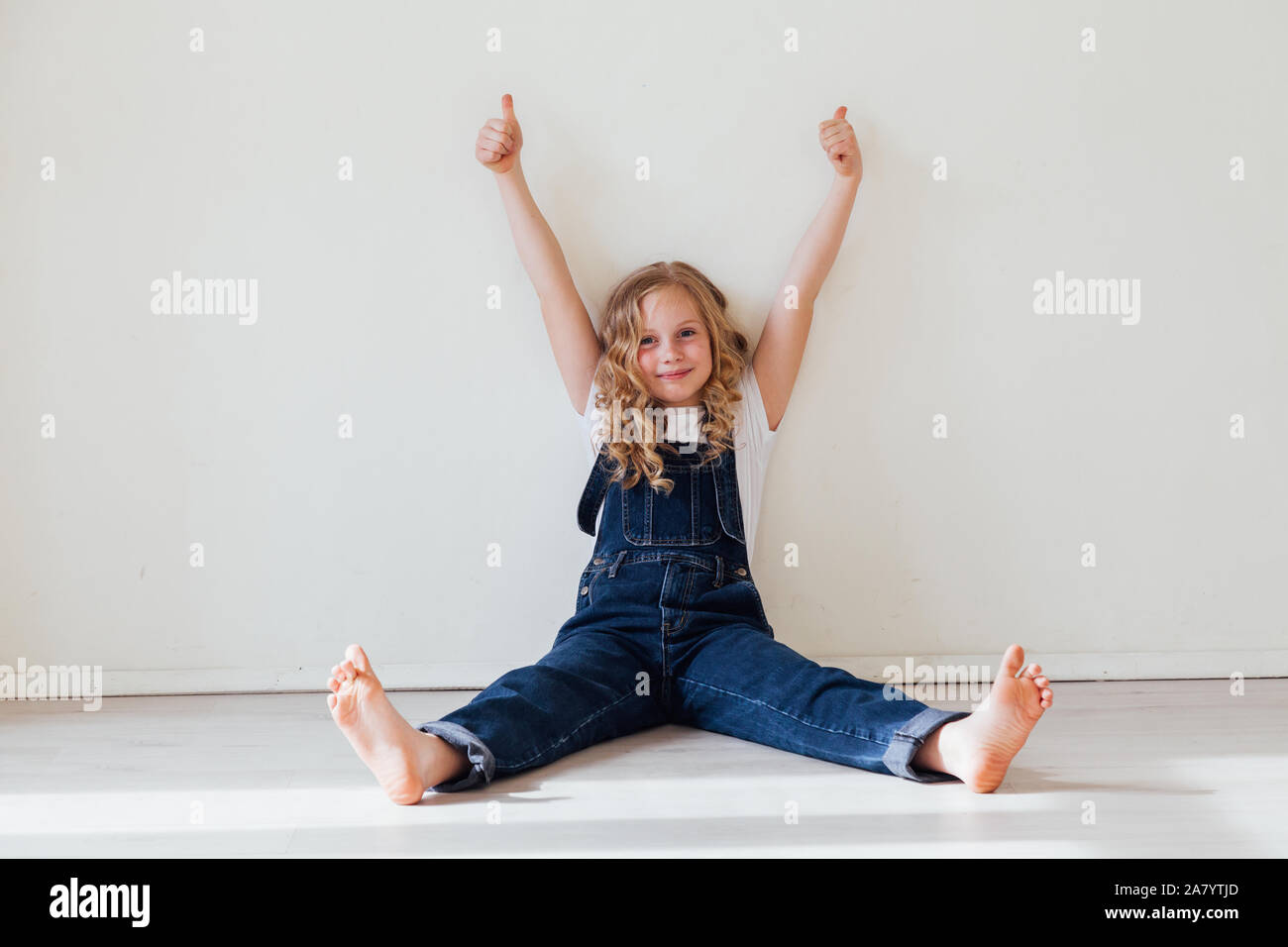 Portrait of a beautiful blonde girl in a denim jumpsuit Stock Photo - Alamy