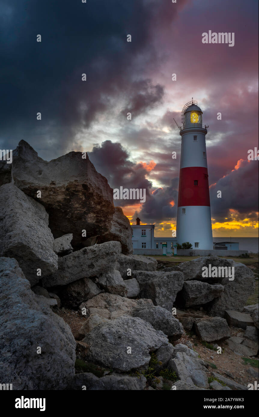 Stormy skies at sunrise at Portland Bill, showing the famous ighthouse Stock Photo