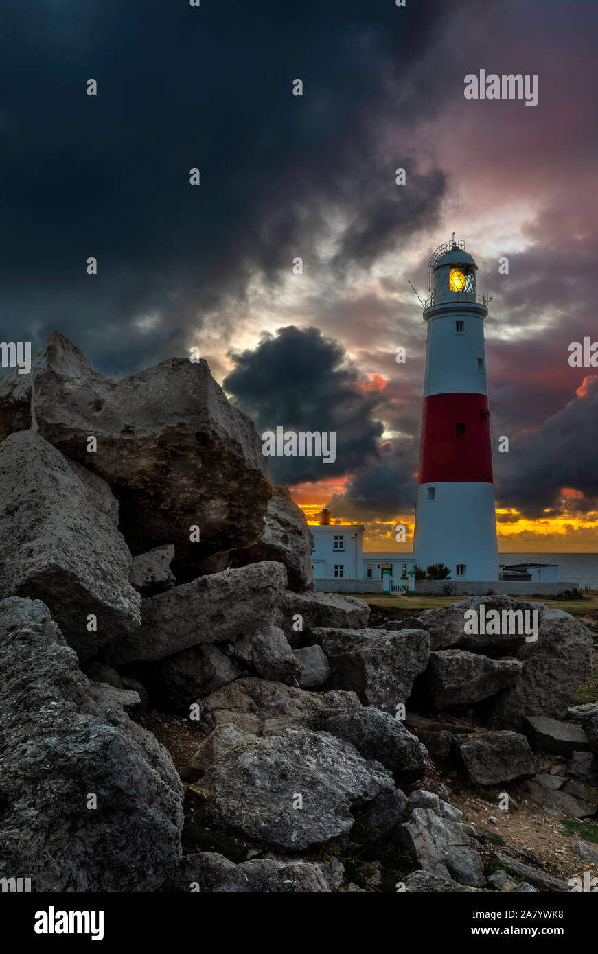 Stormy skies at sunrise at Portland Bill, showing the famous ighthouse Stock Photo