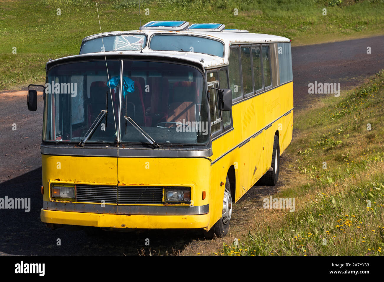 Old vintage yellow bus parked outdoors in Vestmannaeyjar, Iceland Stock Photo