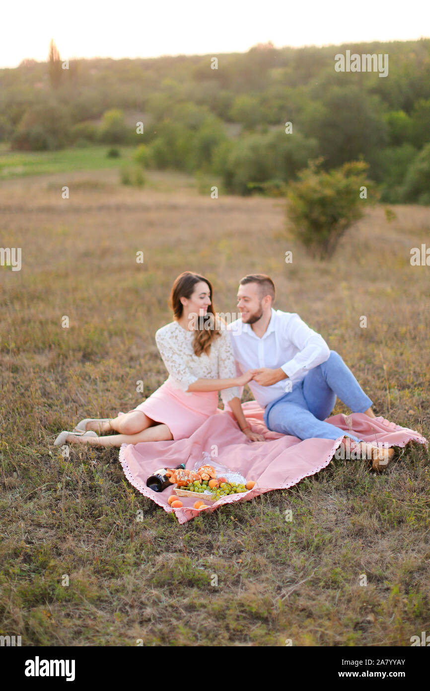 Lifestyle, happy couple resting at a picnic in the park with a dog ...