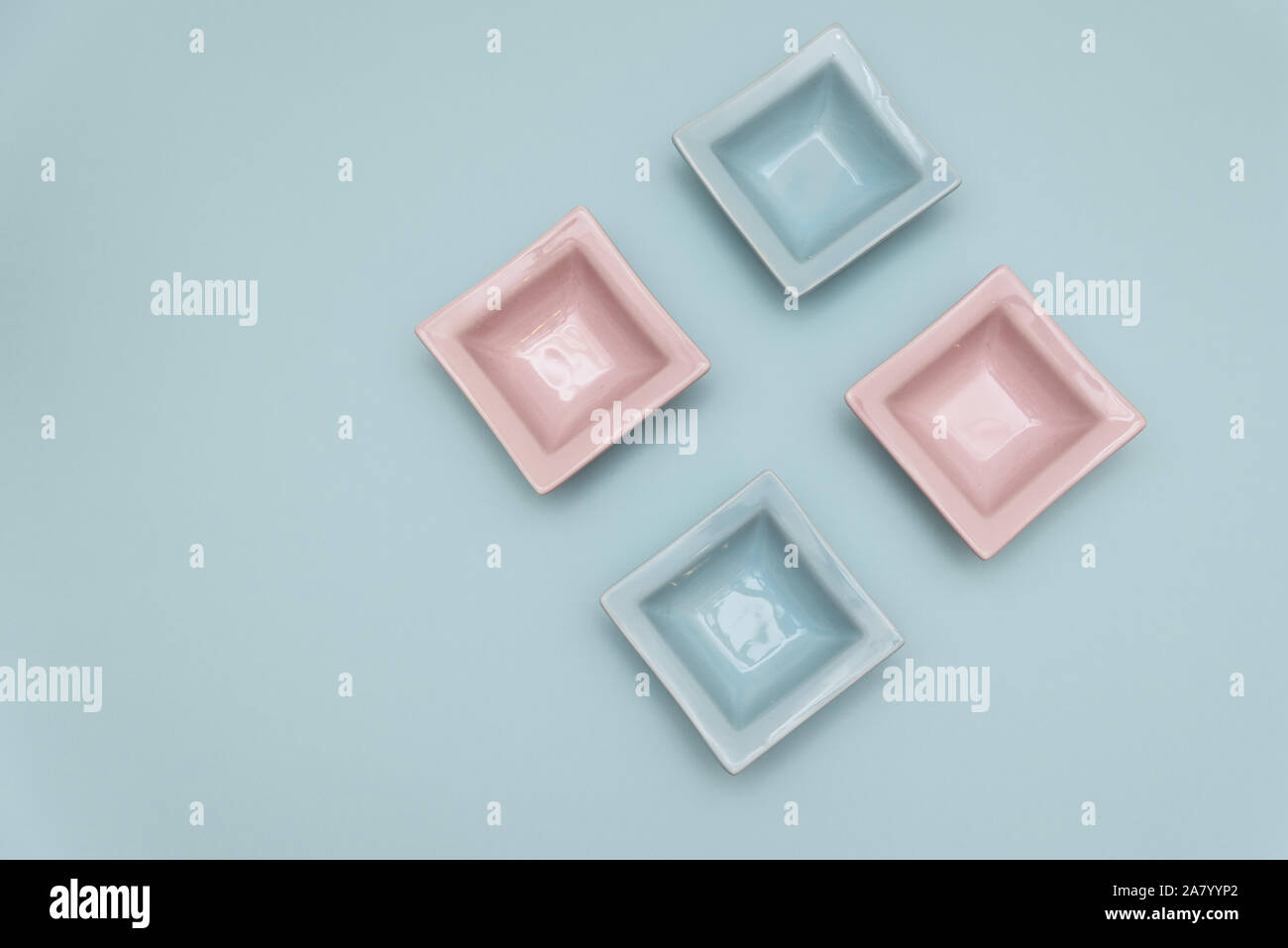 Four small decorative tabletop bowls pink and light blue on a light
