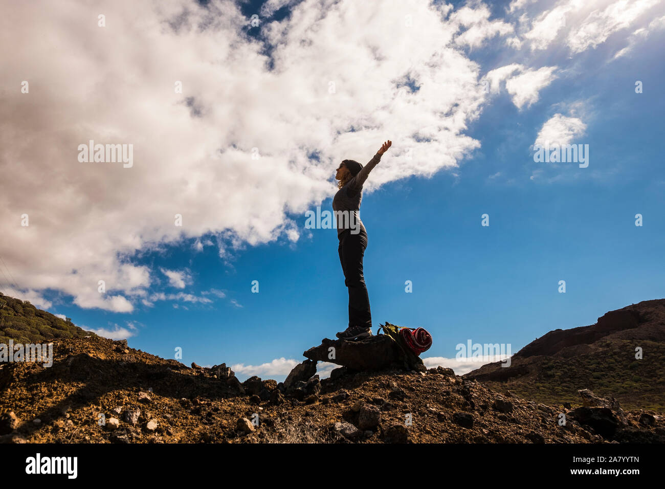 People having success in healthy outdoor leisure activity - trekking and adventure on mountains - standing woman with open arms enjoying freedom - blu Stock Photo