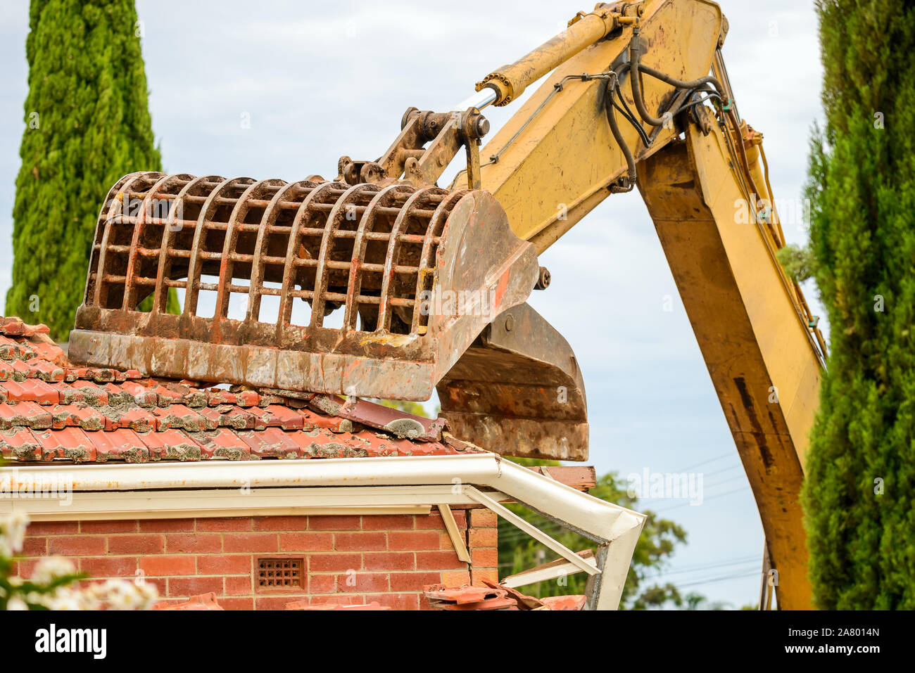 Old Australian suburban house demolition with excavator Stock Photo