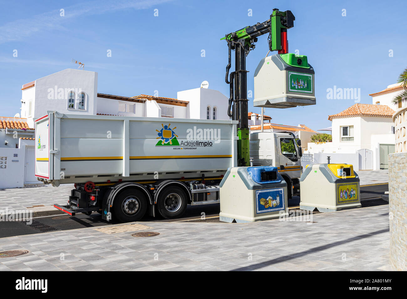 Refuse truck collecting recycled glass from containers by the roadside in La Caleta, Costa Adeje, Tenerife, Canary Islands, Spain Stock Photo