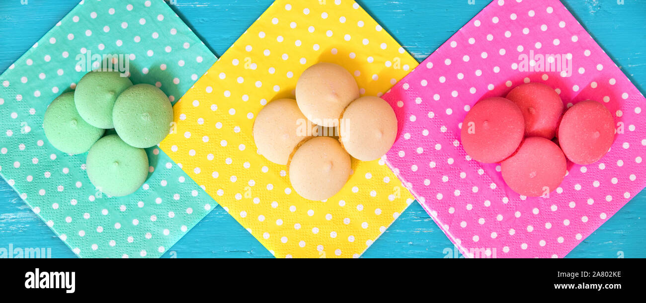 Header, colorful macarons or biscuits on different dotted napkins, topview Stock Photo