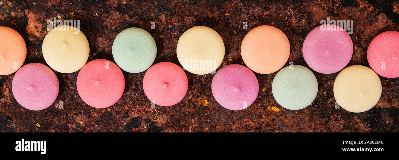 Panorama, Macarons, biscuits or cookies in a line on a rusty background, topview Stock Photo