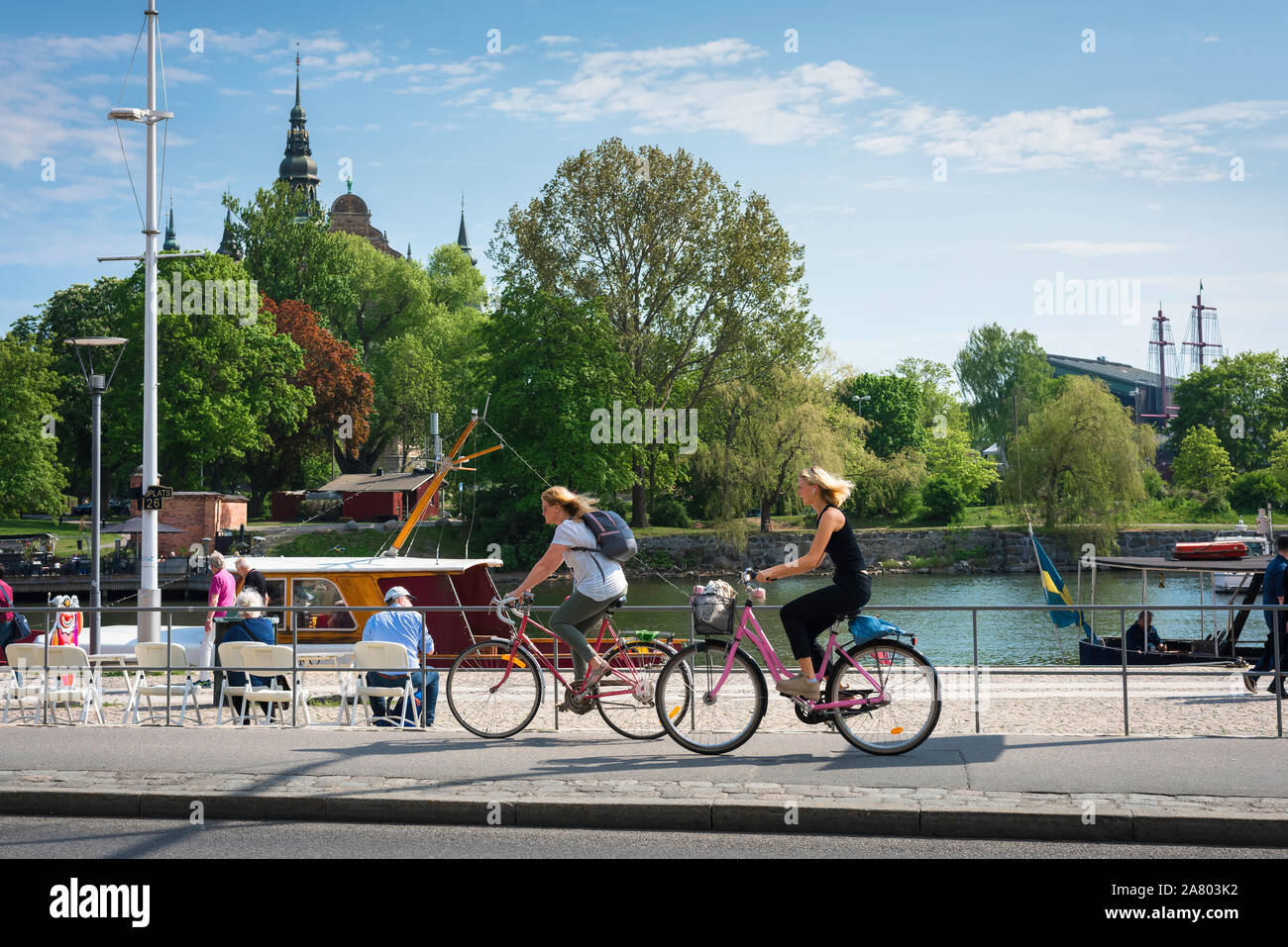 Stockholm summer, view in summer of young women cycling in Strandvägen, a waterfront cycle path on Östermalm in Stockholm city center, Sweden. Stock Photo