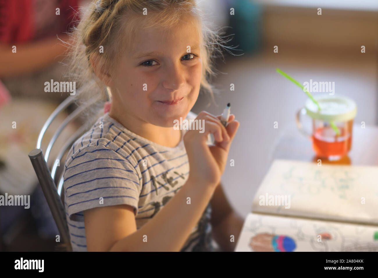 Cute little girl painting a picture in a home interior. Stock Photo