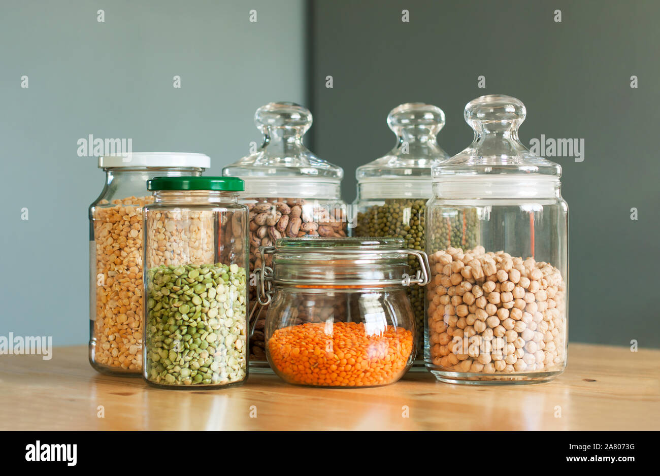 Glass jars with beans in the minimalistic interior. Peas, lentils, mung