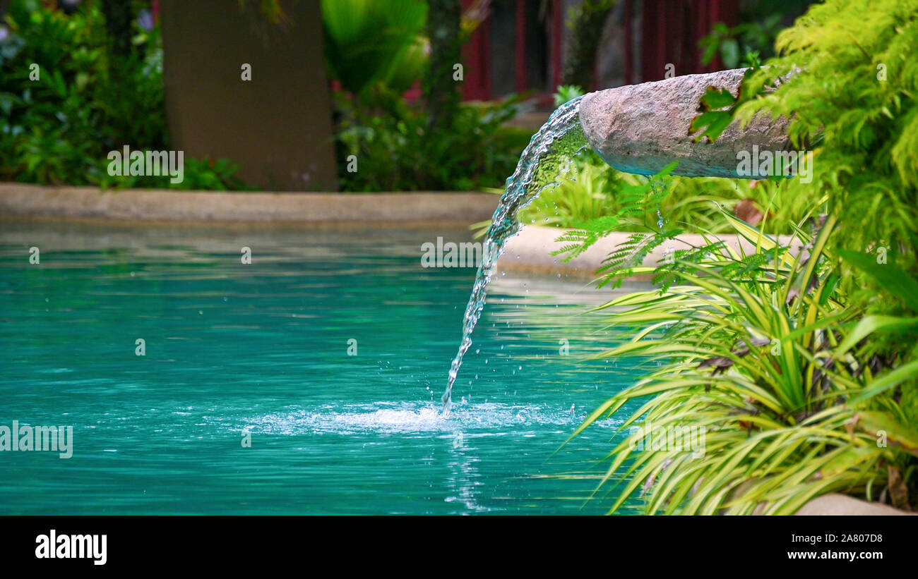 Water flowing water falling into the pond, decoration of the edge of the poo Stock Photo