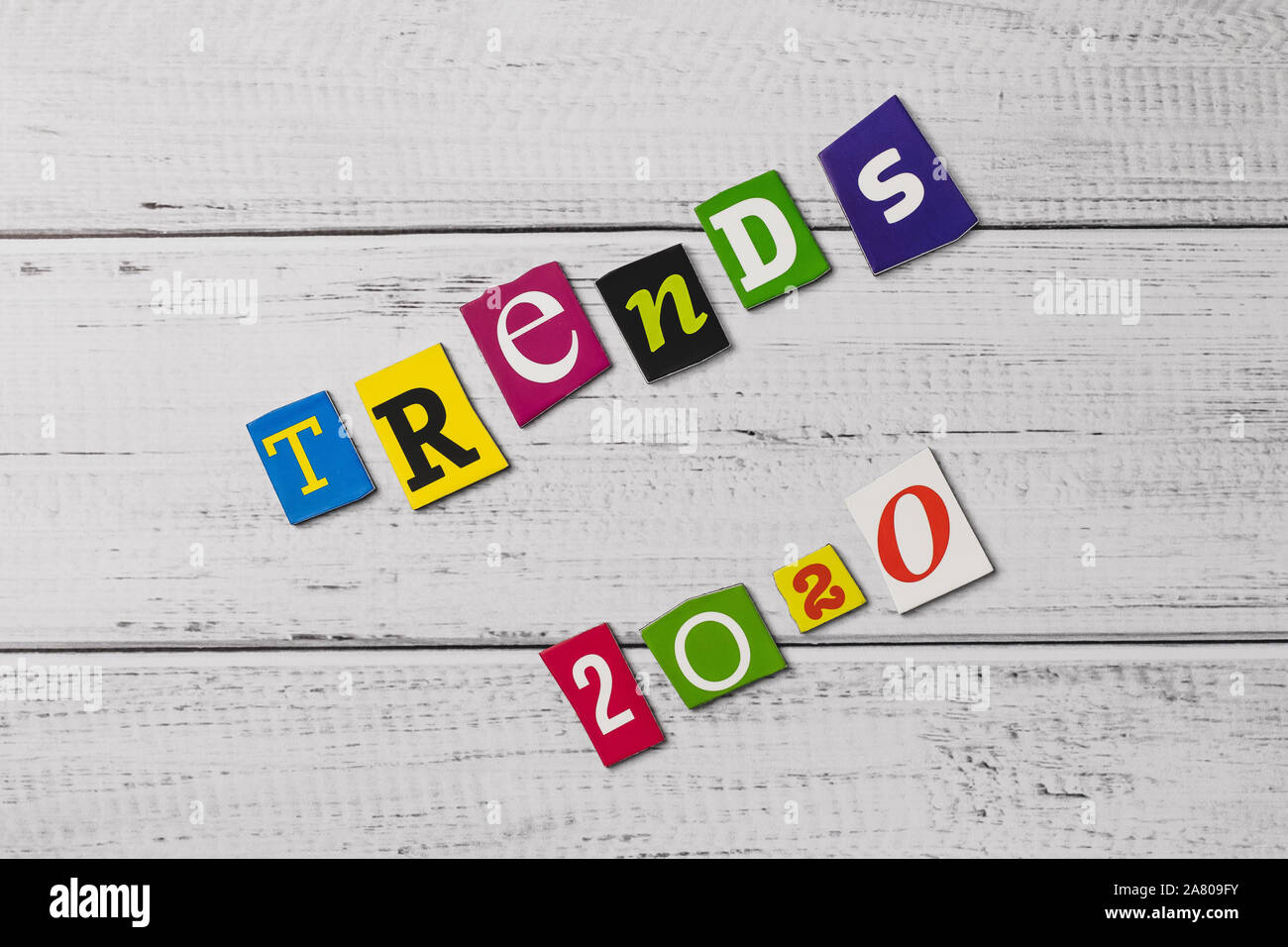 Word on wooden board. Trends - 2020. Cut colorful letters. Card, banner with inscription. Text message. The multicolor words on wood background. The n Stock Photo