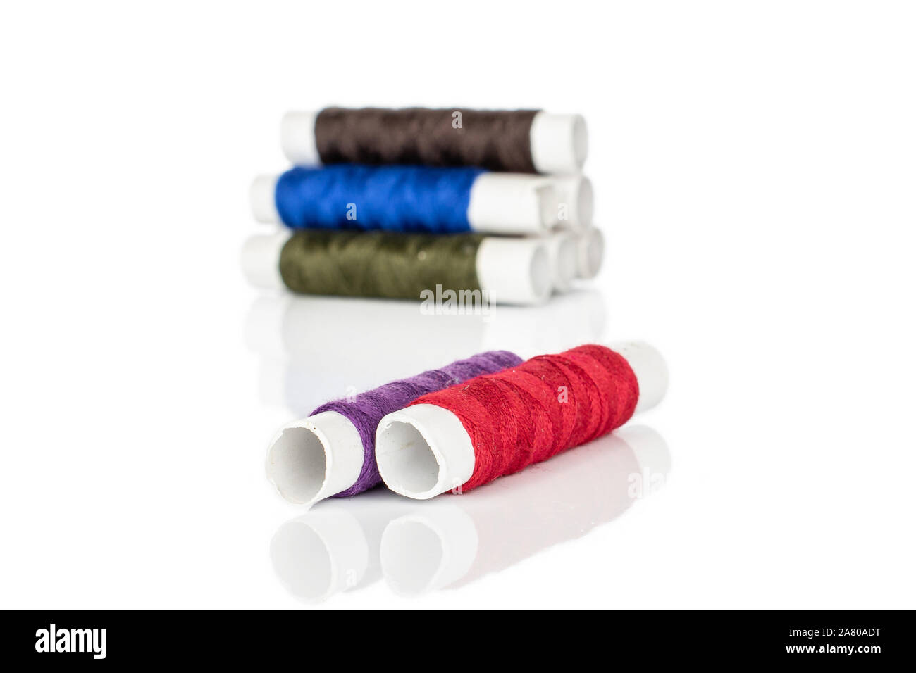 Group of eight whole sewing thread spool two in focus isolated on white background Stock Photo