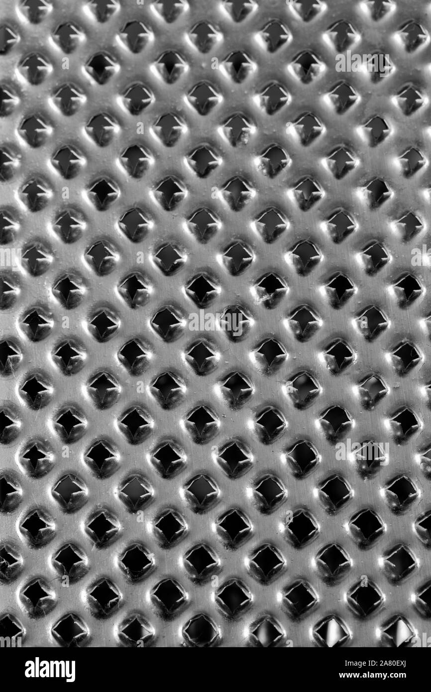 Metal grater, surface with sharp spiky holes, backdrop texture. Gray silver metallic color. Iron kitchen grater chopper Stock Photo