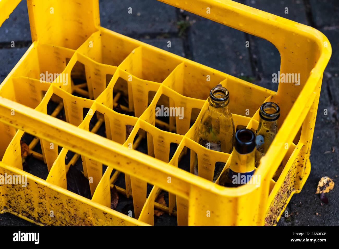 Several empty bottles in yellow plastic container Stock Photo