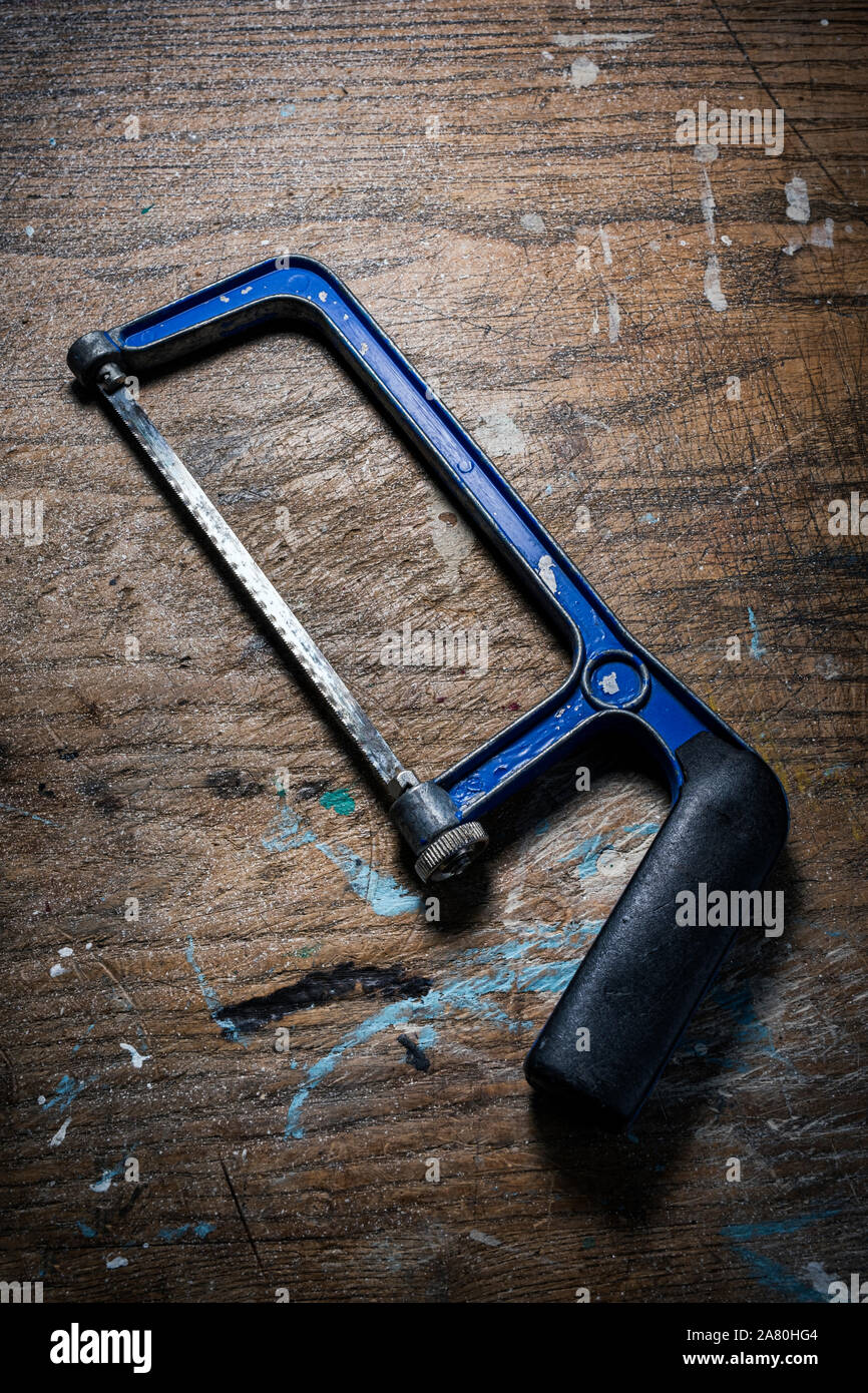 Junior hacksaw on a wooden work bench. Stock Photo