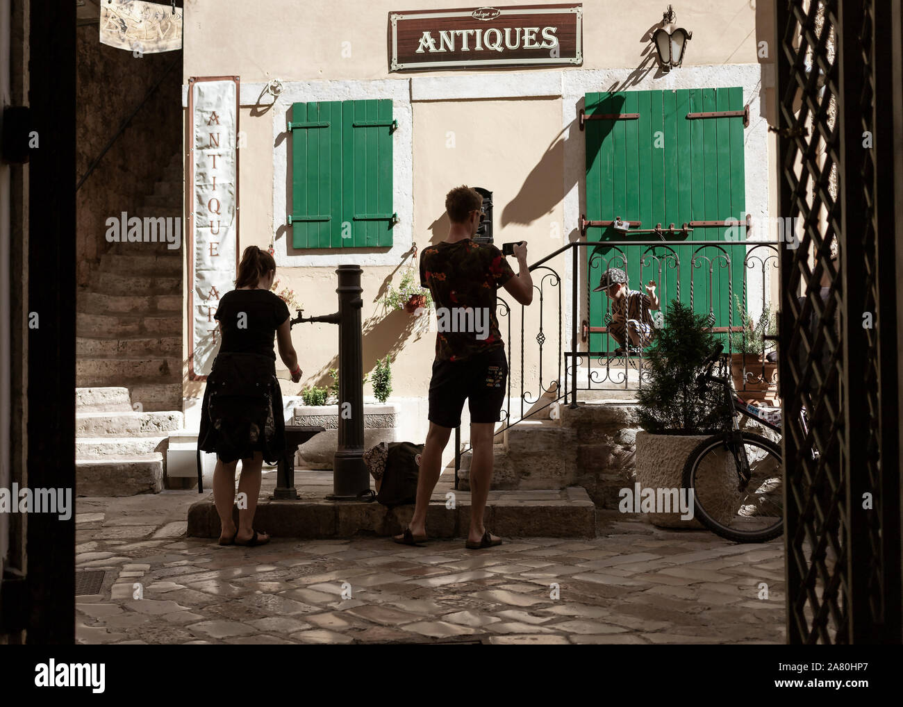 Montenegro, Sep 21, 2019: Young couple with little son taking break around drinking fountain in Kotor Old Town Stock Photo
