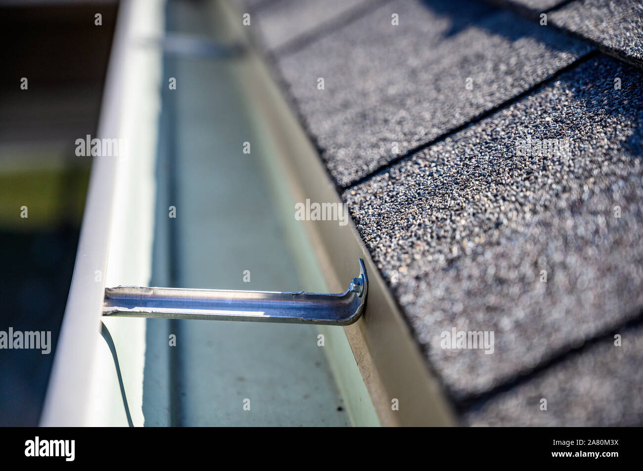 view inside roof gutter with clips and edge of shingles Stock Photo Alamy