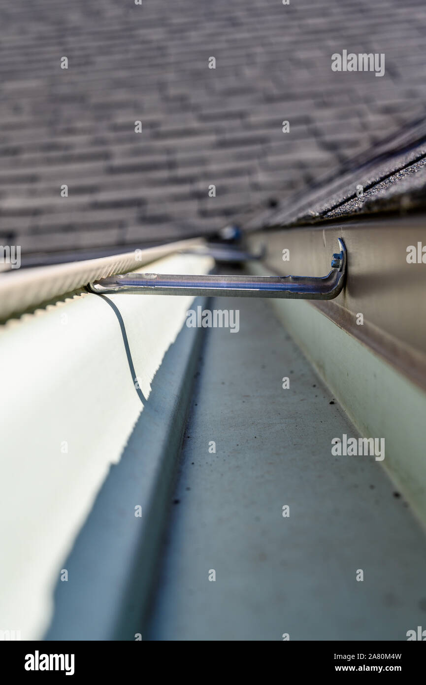 view inside roof gutter with clips and edge of shingles Stock Photo Alamy