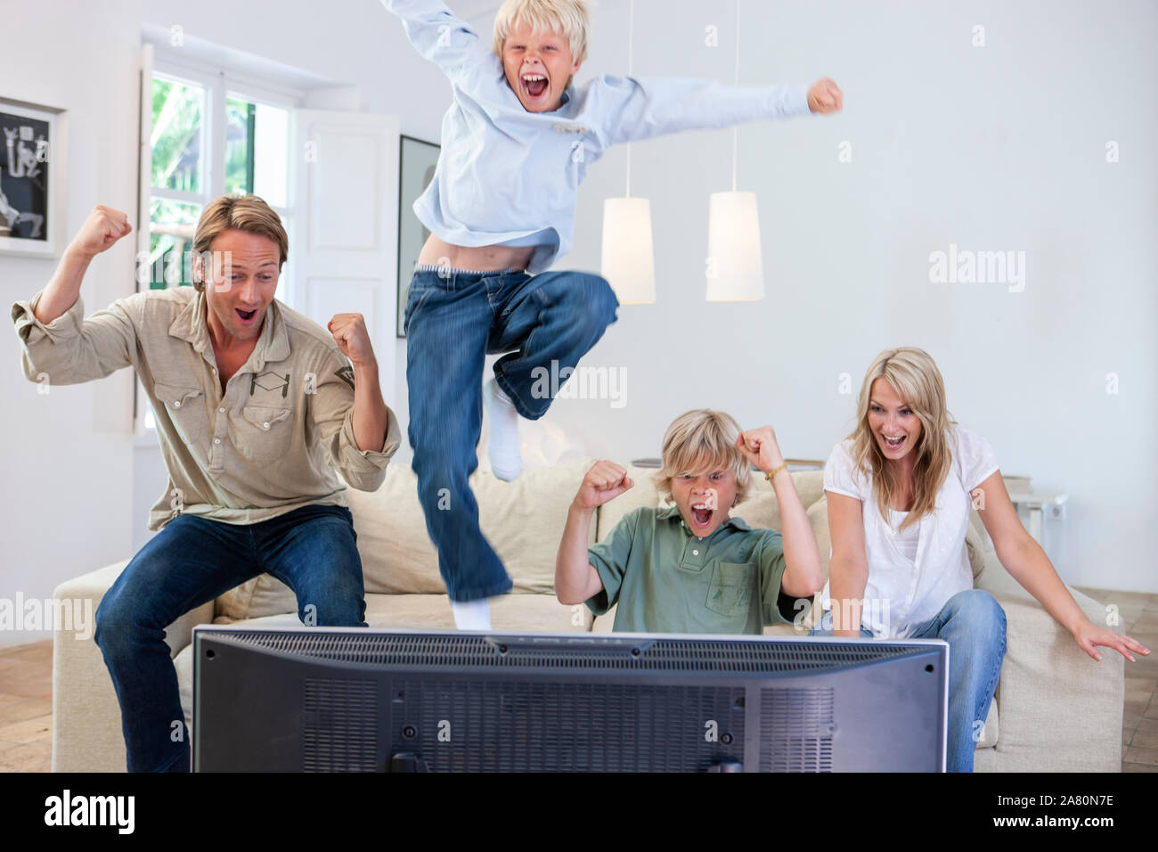 Family celebrating a victory on TV Stock Photo