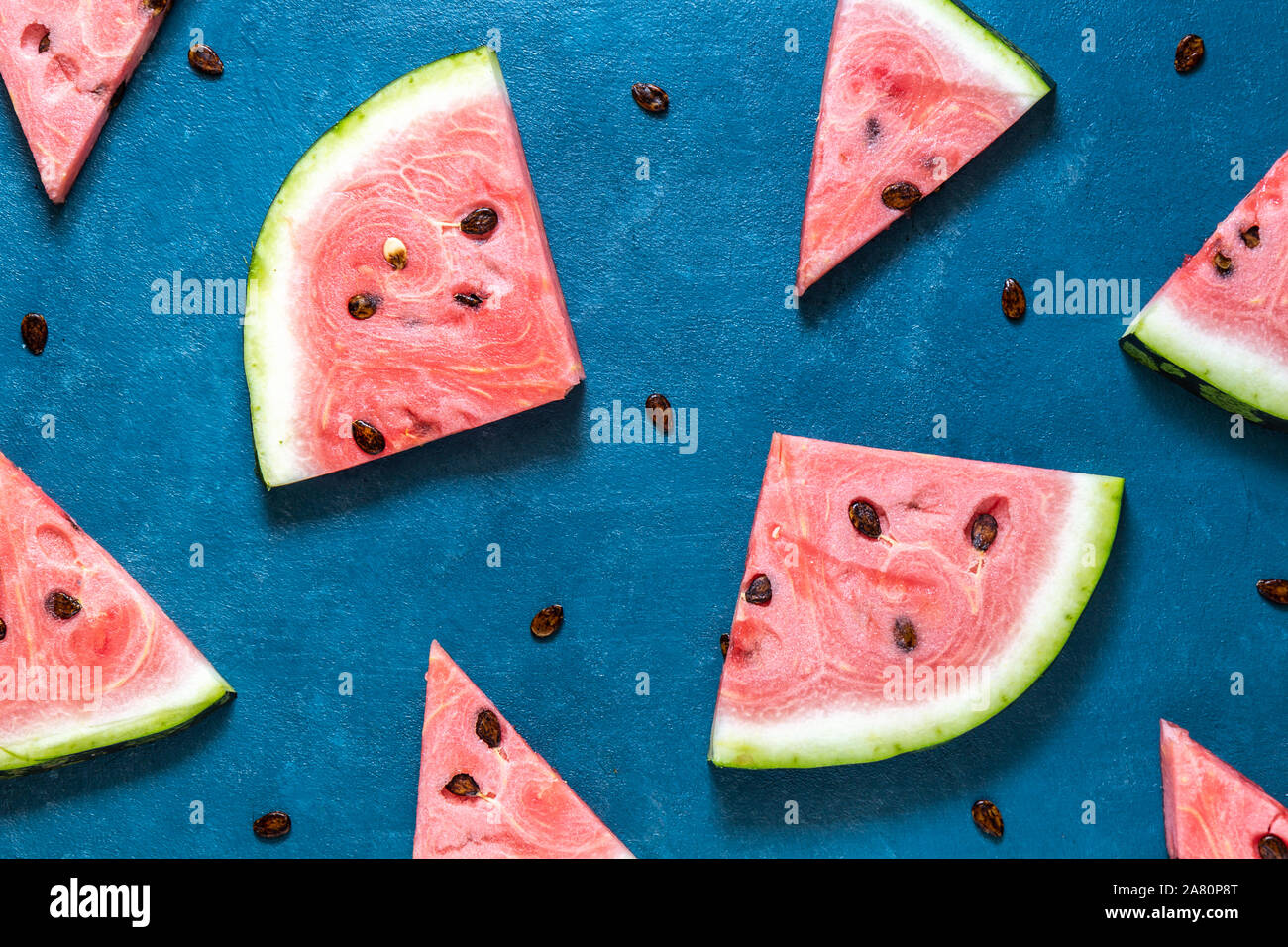 Triangular slices of watermelon lie on a blue background. Top view ...