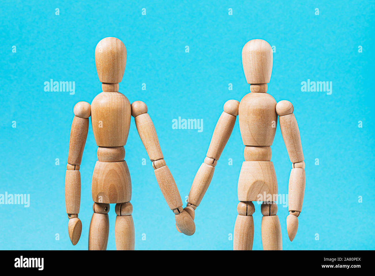 Relationship between people. Two wooden mannequins hold hands. Stock Photo