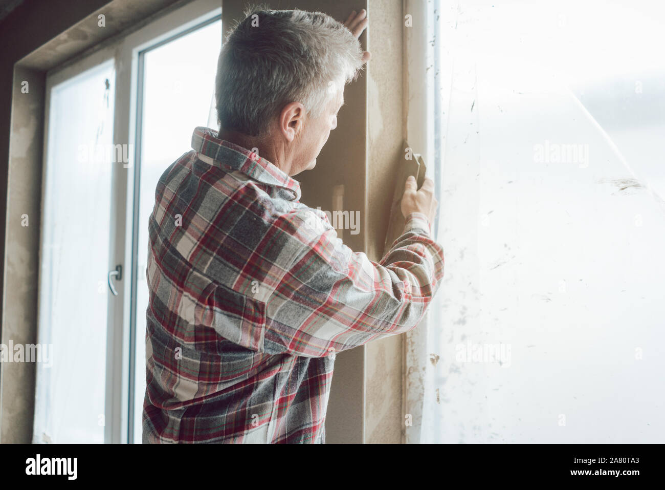 Plasterer working on a window opening Stock Photo