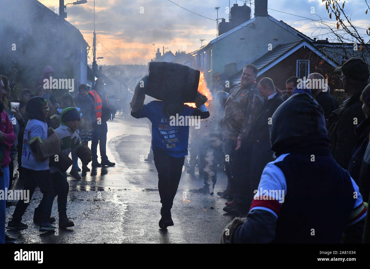 Children from the village of Ottery St Mary in Devon carry traditional burning tar barrels through the streets of the village on bonfire night. Stock Photo