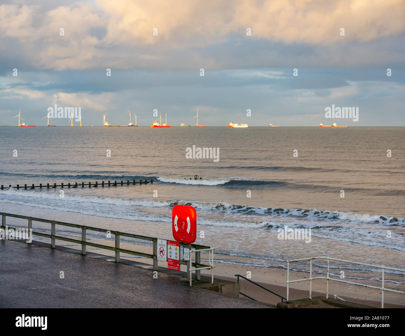 View of North Sea from Aberdeen esplanade &  beach with offshore wind farm and supply ships, Northeast Scotland, UK Stock Photo