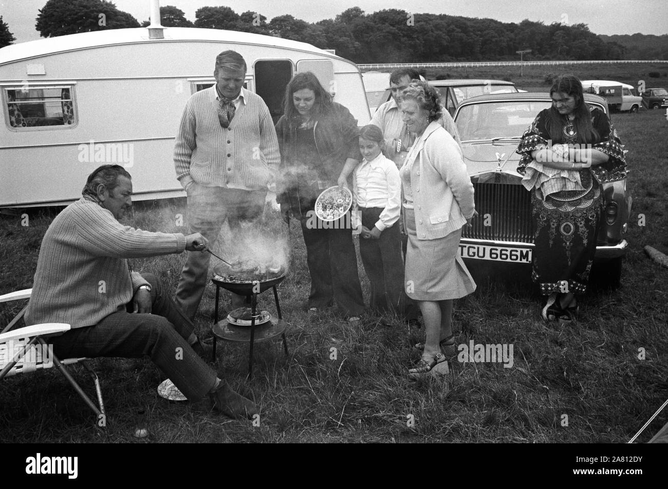 A wealthy gypsy family barbecue, with Rolls Royce and caravan, Derby Day horse race,  Epsom Downs, Surrey, England 1974. 1970s UK HOMER SYKES Stock Photo