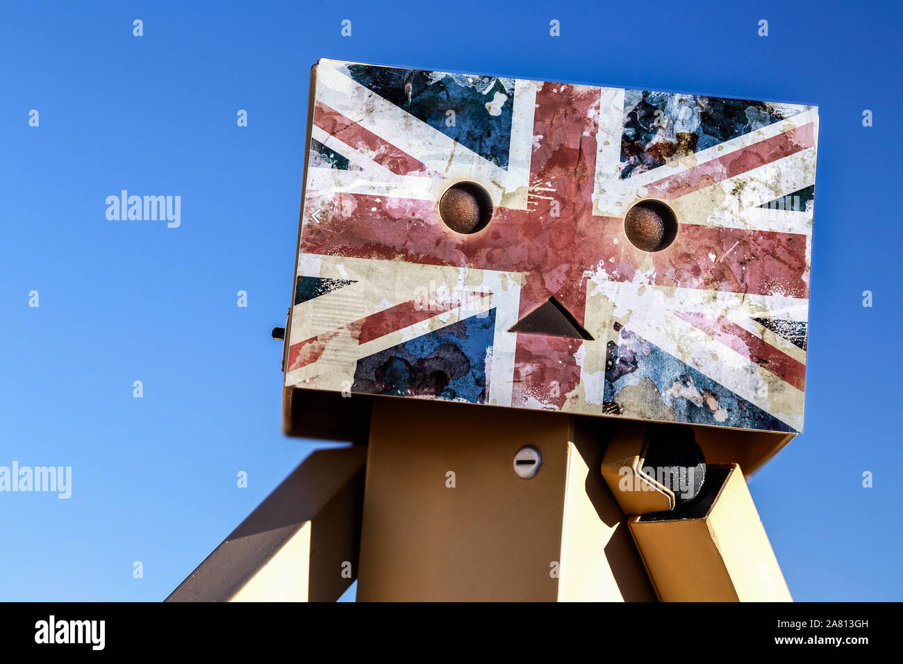 A Danbo Danboard toy robot cardboard box character with a worn union jack emblem across its cardboard face. Stock Photo