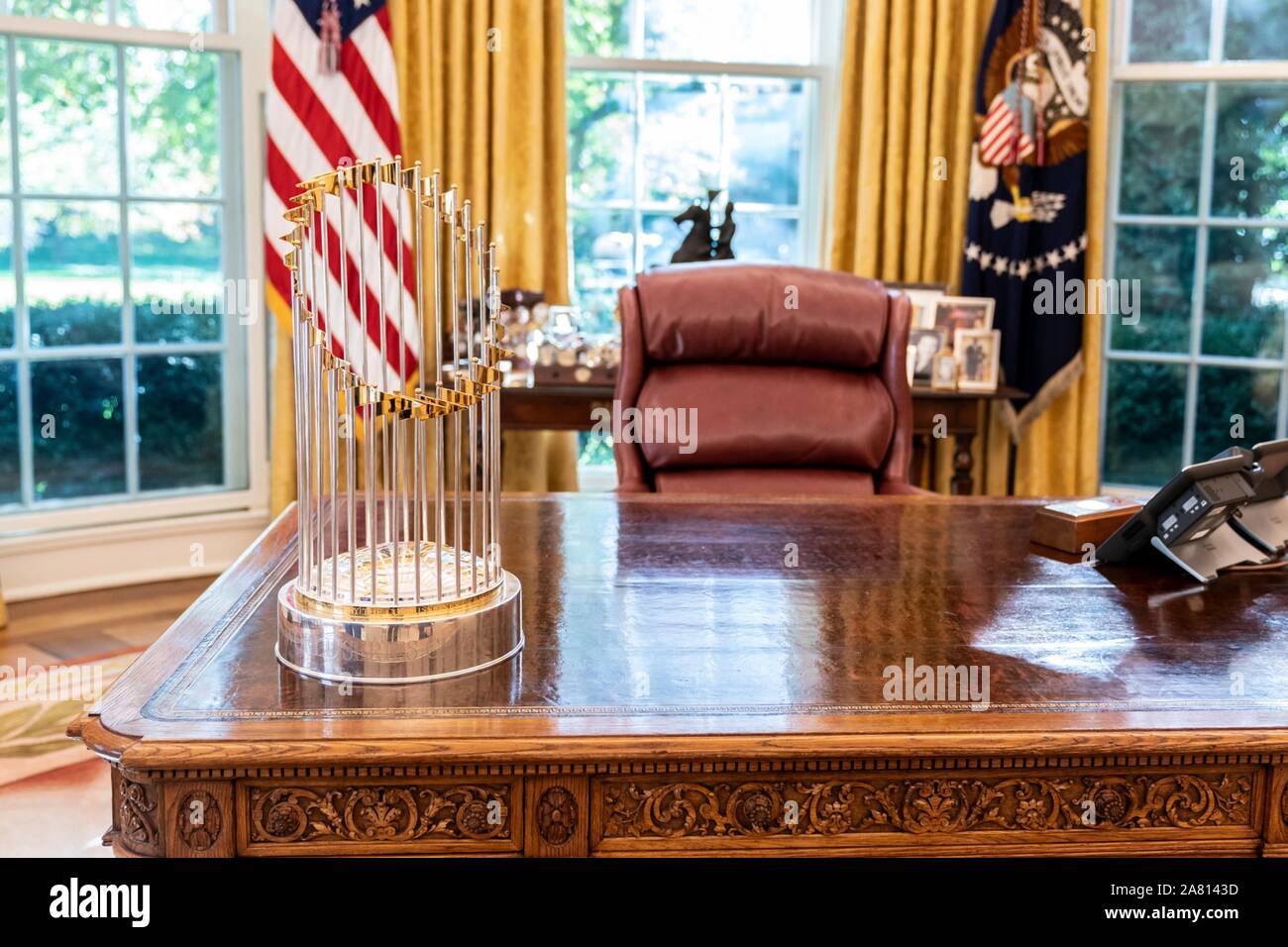 Washington, United States of America. 04 November, 2019. The World Series Baseball trophy is displayed on the Resolute Desk inside the Oval Office of the White House November 4, 2019 in Washington, DC. U.S. President Donald Trump hosted the 2019 Championship Washington Nationals for a victory celebration at the White House.   Credit: Shealah Craighead/White House Photo/Alamy Live News Stock Photo