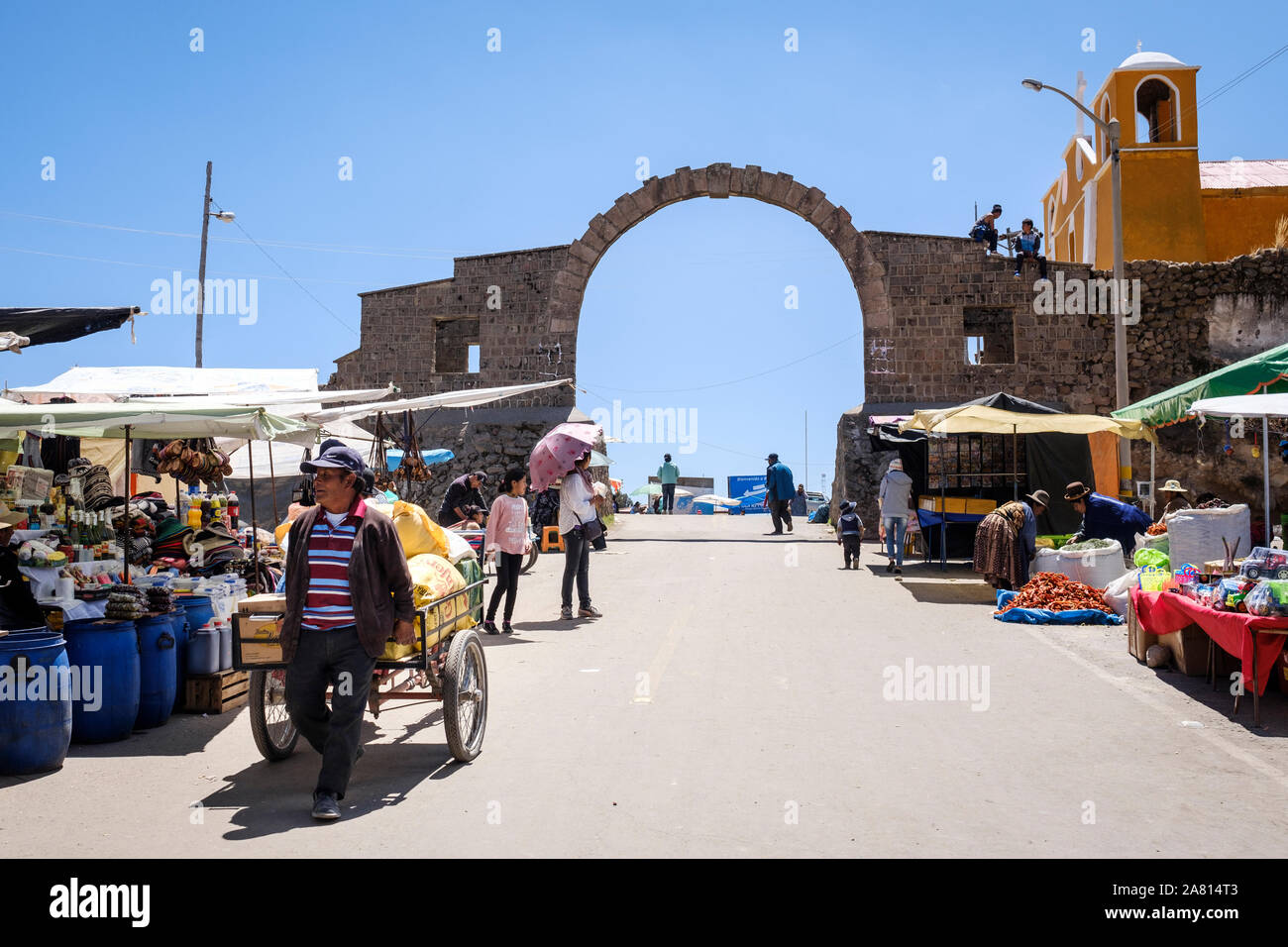 People walking on street market in the Peru side of the Peru-Bolivia border near Puno Stock Photo