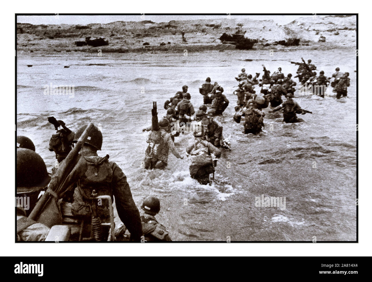 UTAH BEACH, FRANCE:  US American troops disembark from landing crafts and wade ashore under heavy intrenched Nazi fire during D-Day 06 June 1944. Allied forces stormed the Normandy beaches. The Allied landing in Normandy led to the liberation of France which marked the turning point in the Western theater of World War II. Stock Photo