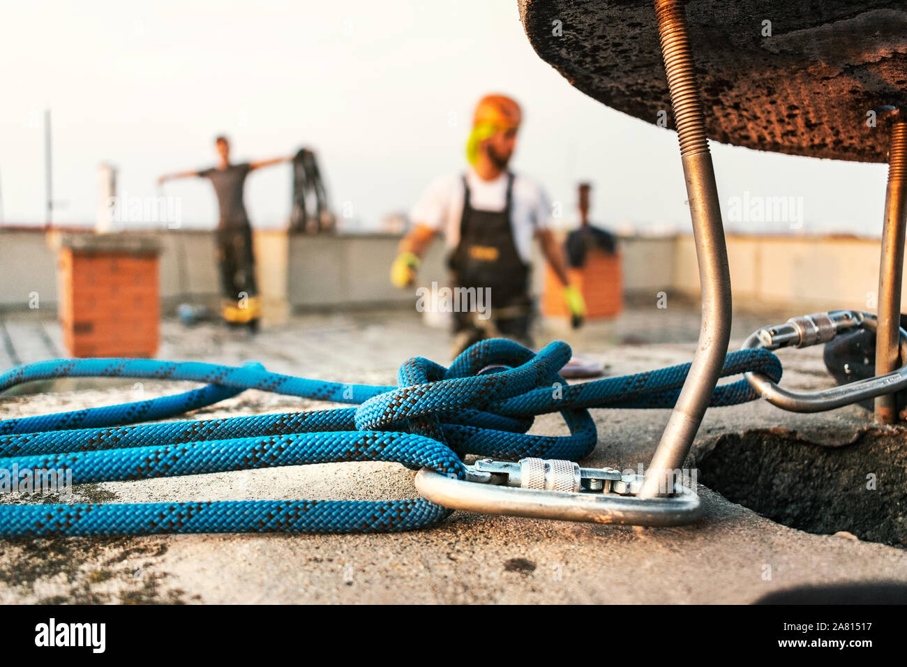 Industrial rope access worker wearing professional safety gears preparing  his equipment to start working on the facade wall of the tall building.  Indu Stock Photo - Alamy