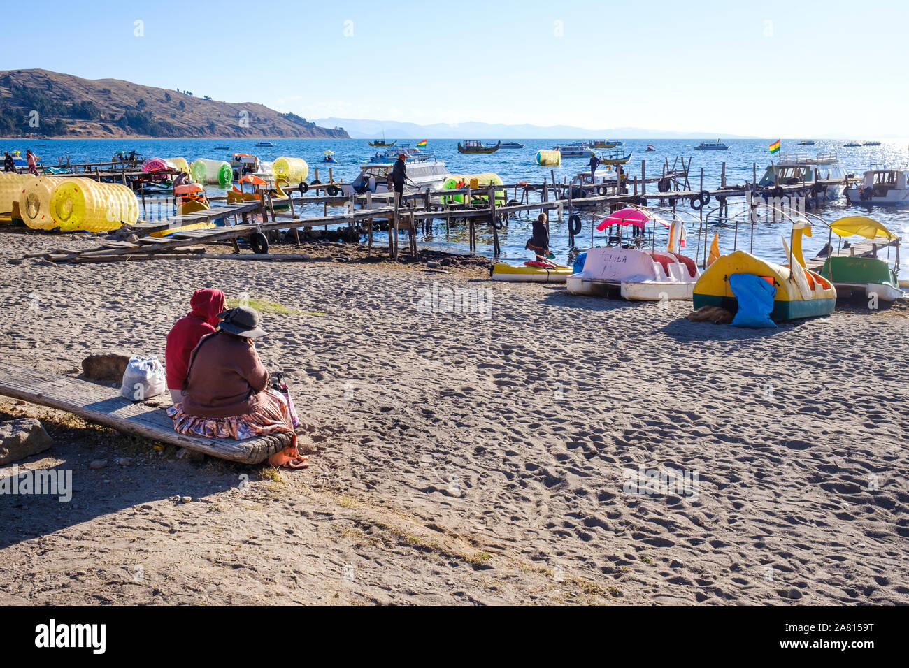 Local people and duck-shaped boats in Copacabana beach, Bolivia Stock Photo