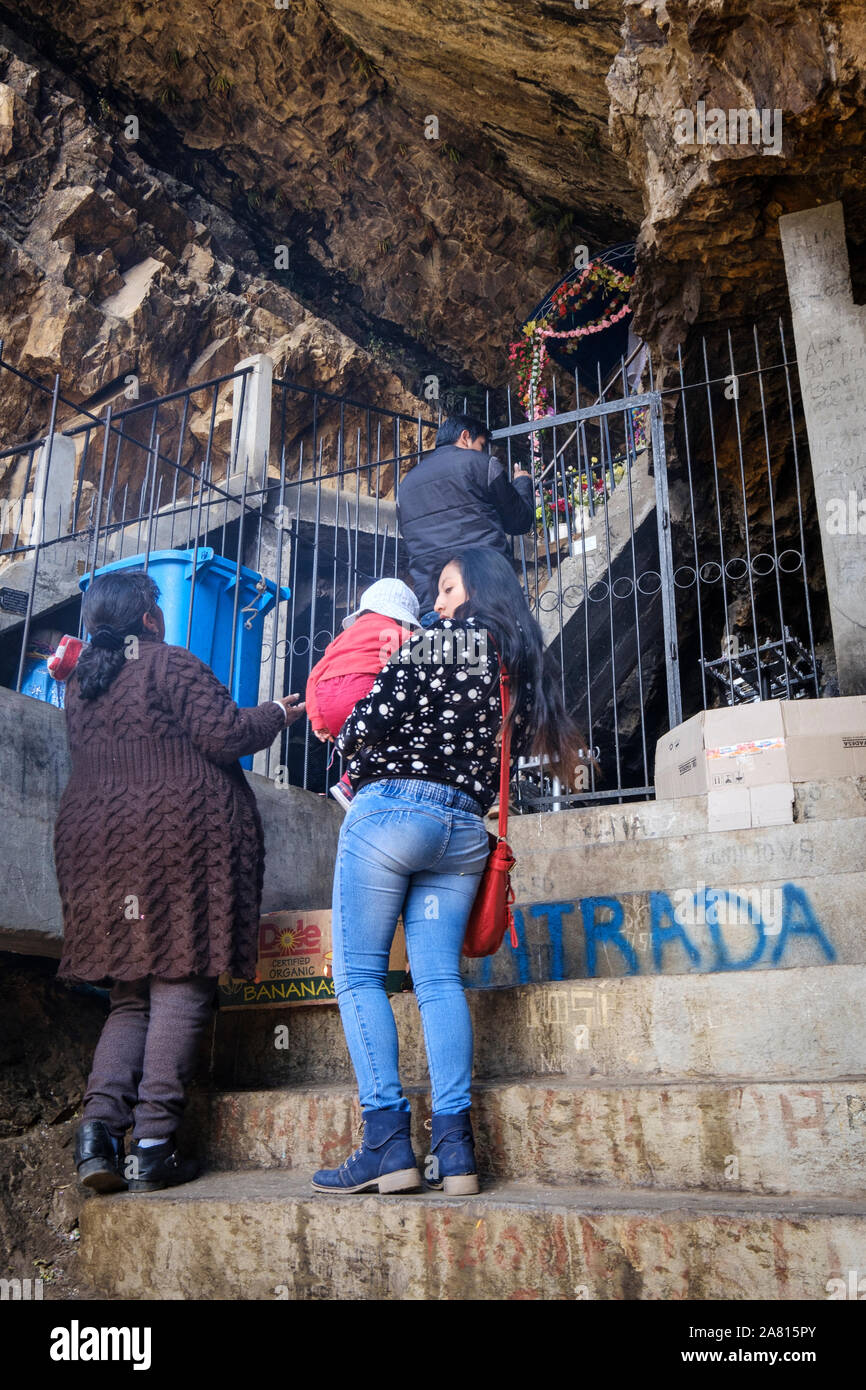 Local people worshipping the Virgin's figure at the Cave of the Virgin of Lourdes near Copacabana, Bolivia Stock Photo