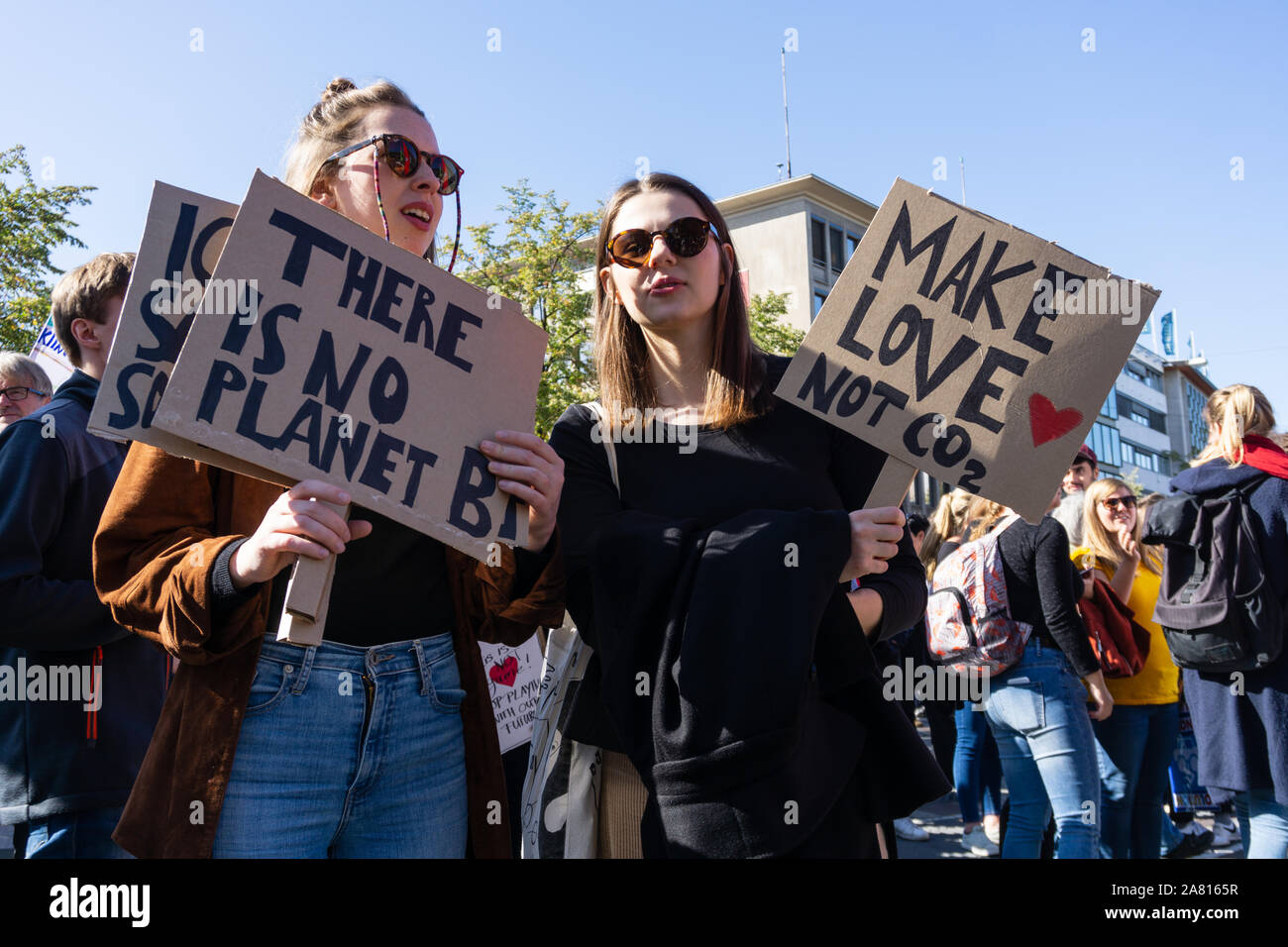 two young women protesting against current politics regarding the worldwide climate change crisis with protest signs in their hands Stock Photo