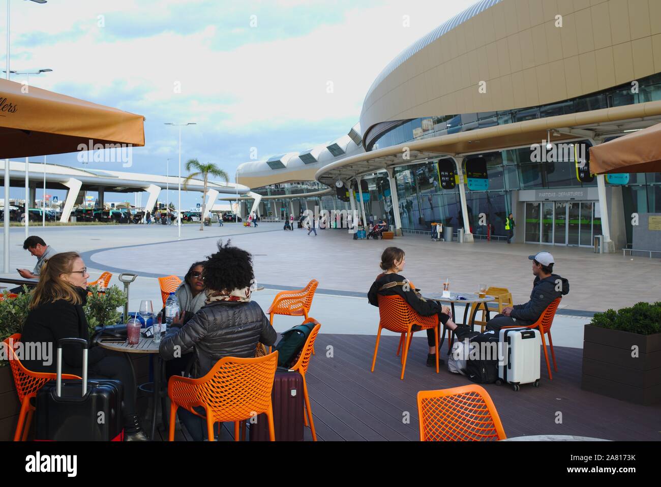 Travellers waiting for flights in outdoor cafe at Faro airport. Algarve, Portugal Stock Photo