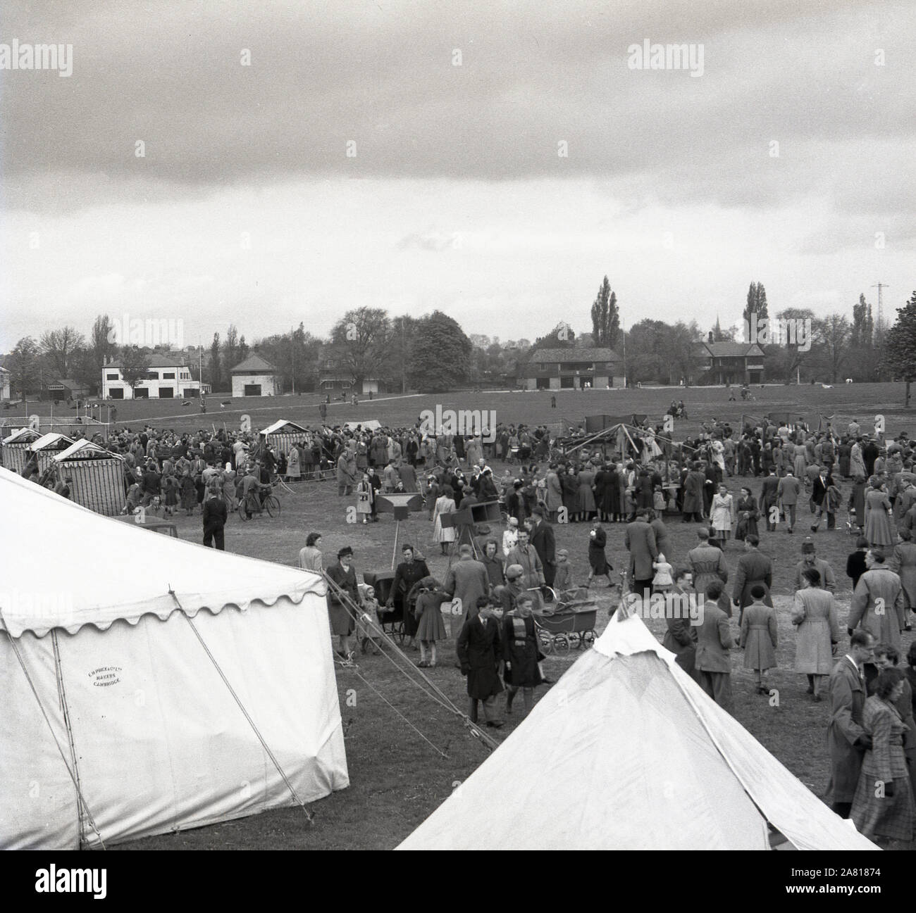 1950s history, visitors to a summer fayre and outdoor tented exhibition in the sports grounds of Cambridge University, England, UK. Stock Photo