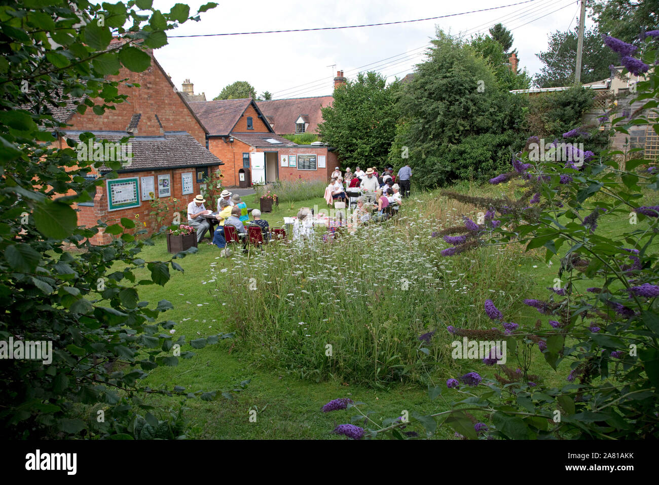 Church group holding outdoor service in Three Bees Community wildlife garden behind Mickleton Methodist Church, Chipping Campden, UK Stock Photo