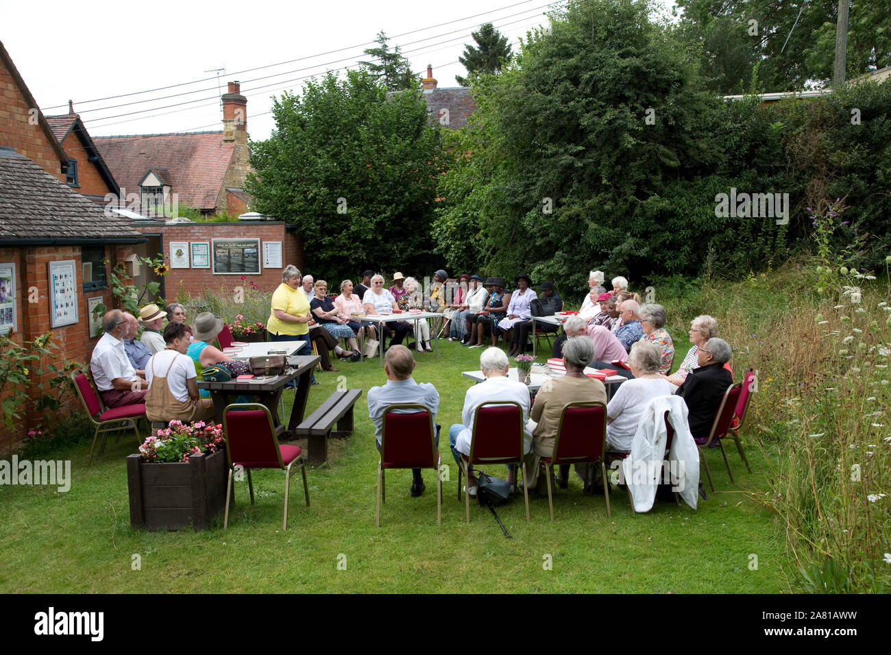 Church group holding outdoor service in Three Bees Community wildlife garden behind Mickleton Methodist Church, Chipping Campden, UK Stock Photo