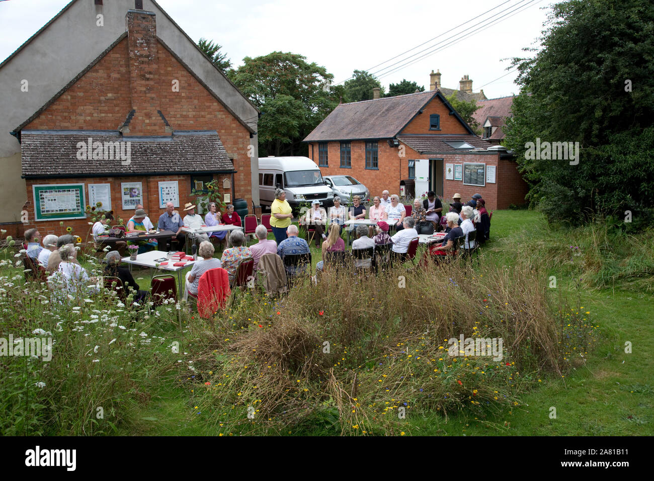 Church group holding outdoor service in Three Bees Community wildlife garden behind Mickleton Methodist Church, Chipping Campden, UK Stock Photo