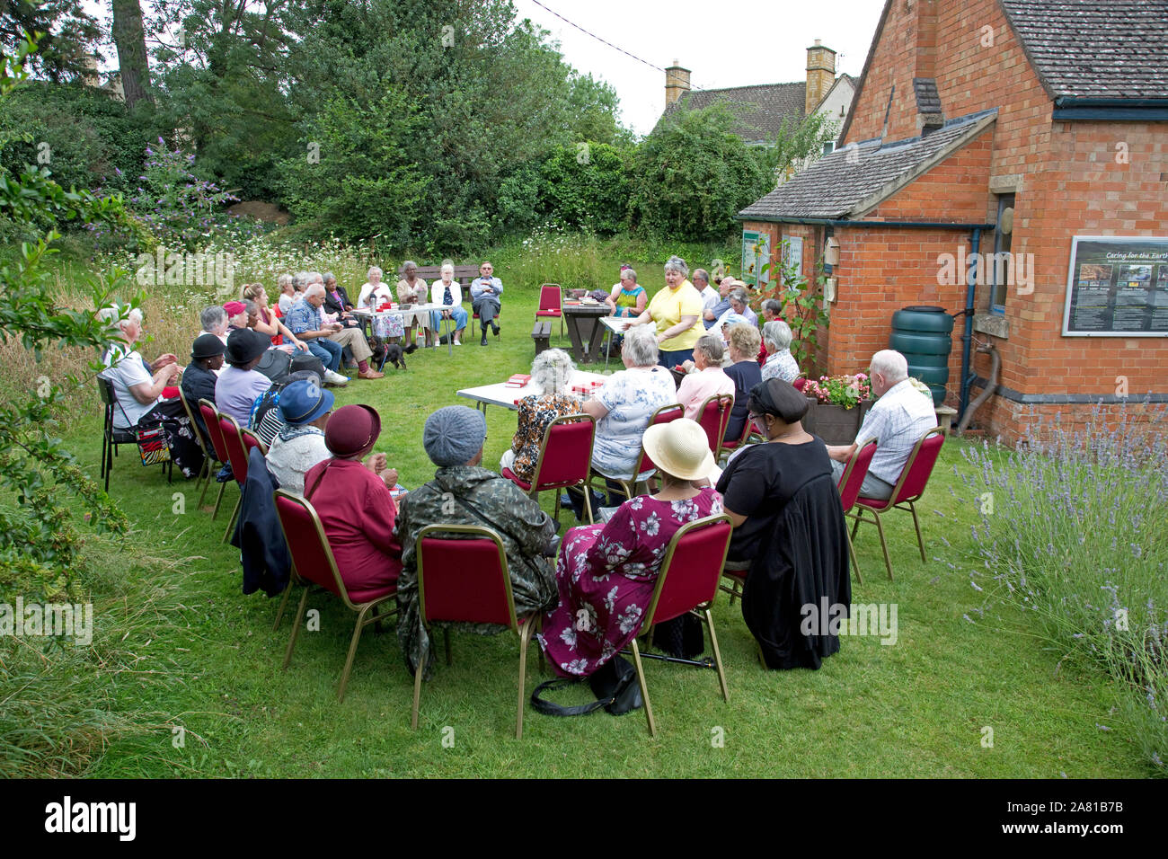 EcoChurch group holding outdoor service in Three Bees Community wildlife garden behind Mickleton Methodist Church, Chipping Campden, UK Stock Photo